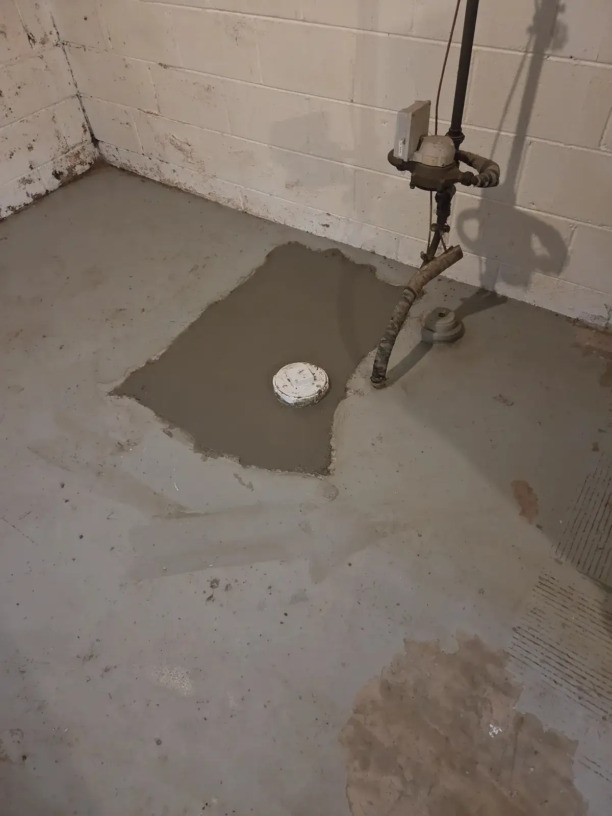 Fresh concrete poured over a finished basement cleanout