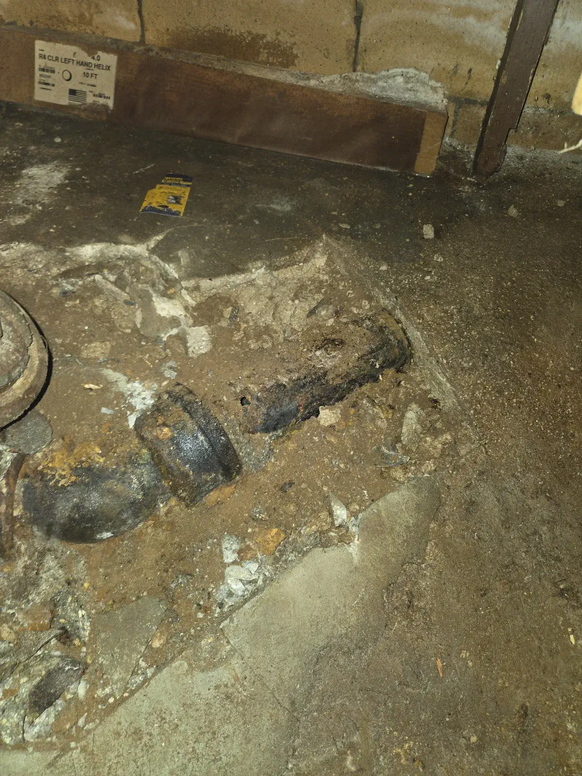 Old cast iron house trap uncovered in a basement floor