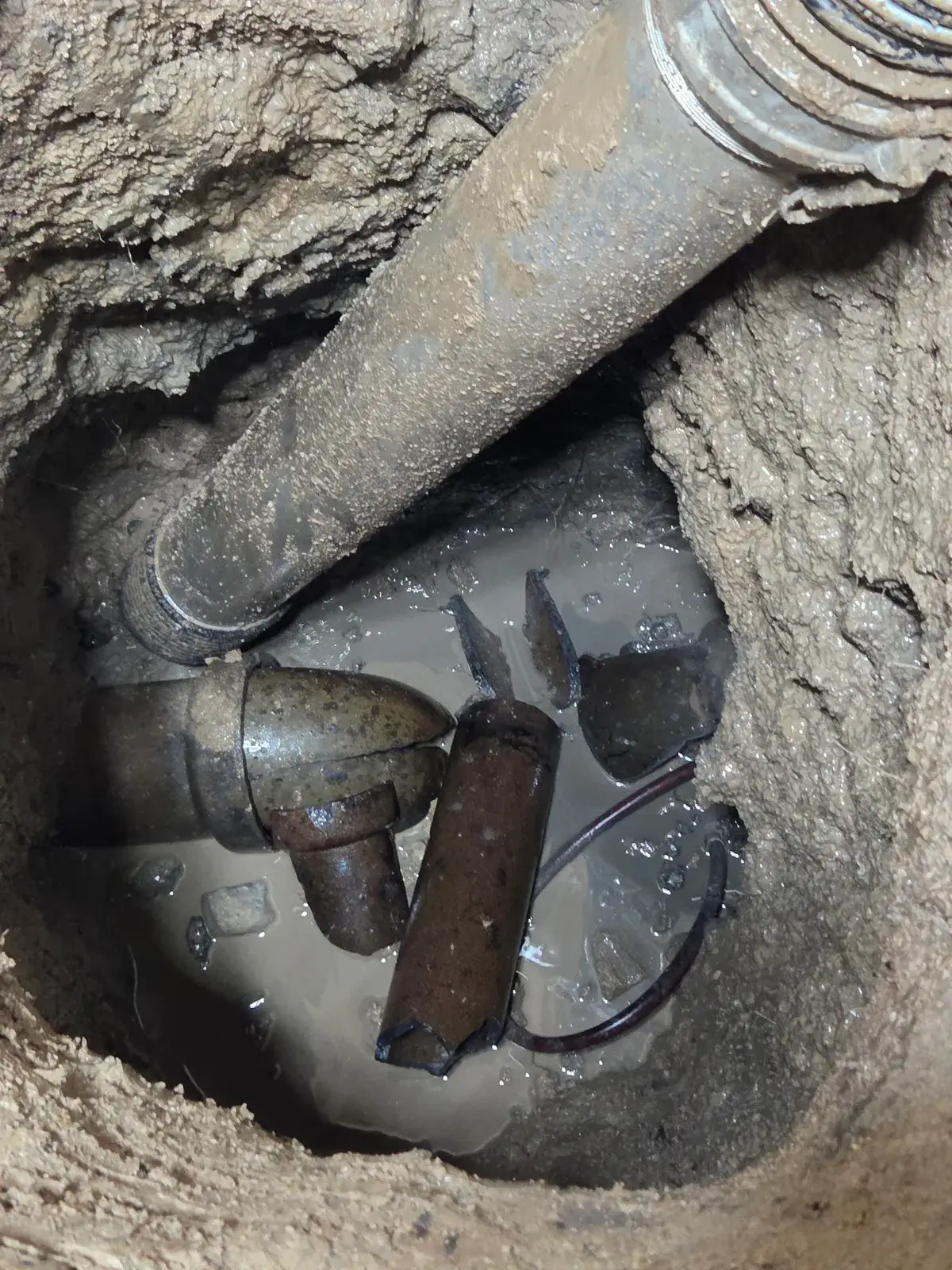 Old house trap and standing water inside an open excavation